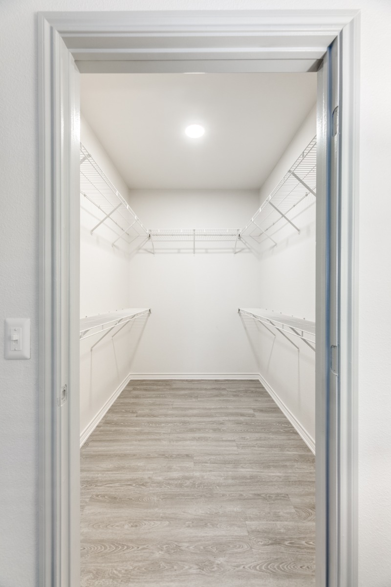 walk-in closet with vinyl wood-look flooring and white-wire shelving